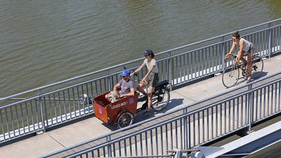 Des nanceiens se baladent à vélo sur une passerelle