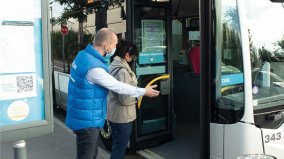 Un accompagnateur guide une personne à entrer dans le bus